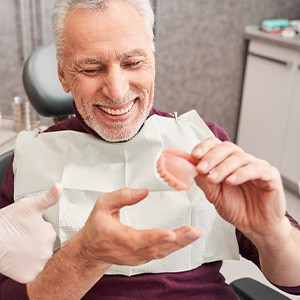 A man looking at a wax denture