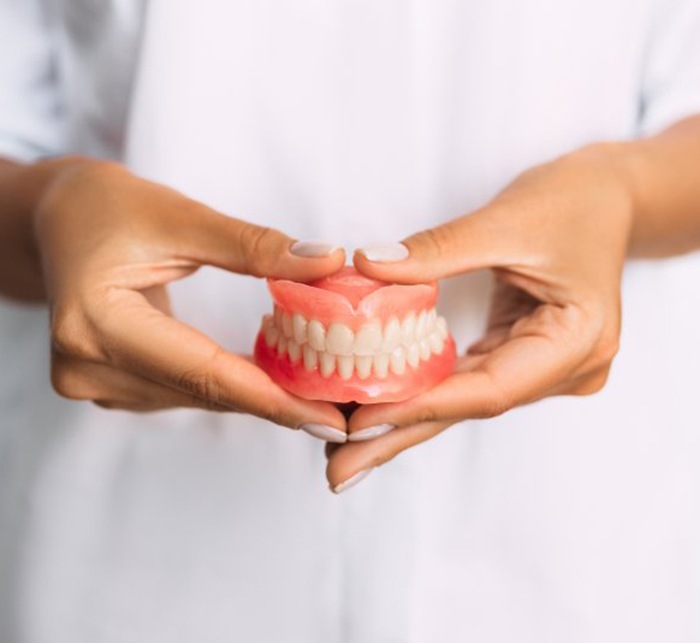 a person holding a nice set of dentures