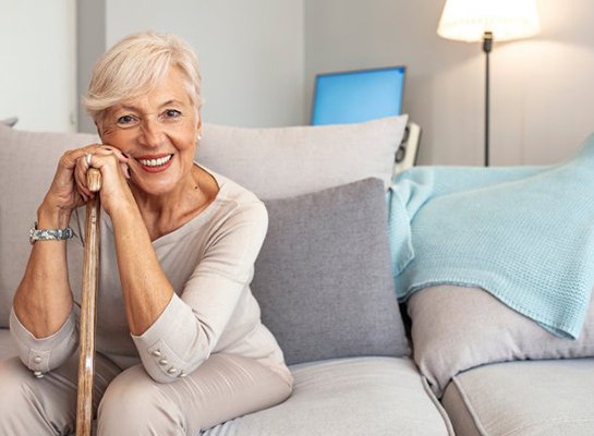 a woman smiling while sitting on her couch