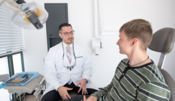 Dentist talking to man in treatment chair about dental services in White Marsh
