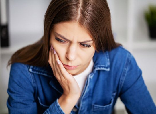 Woman holding her cheek in pain