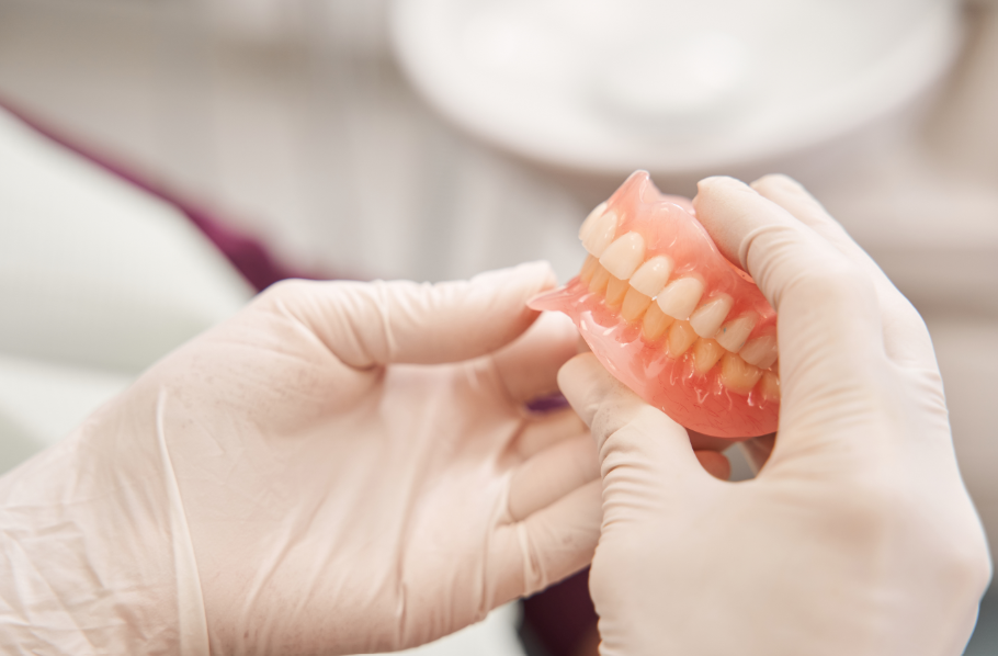 Dentist holding dentures
