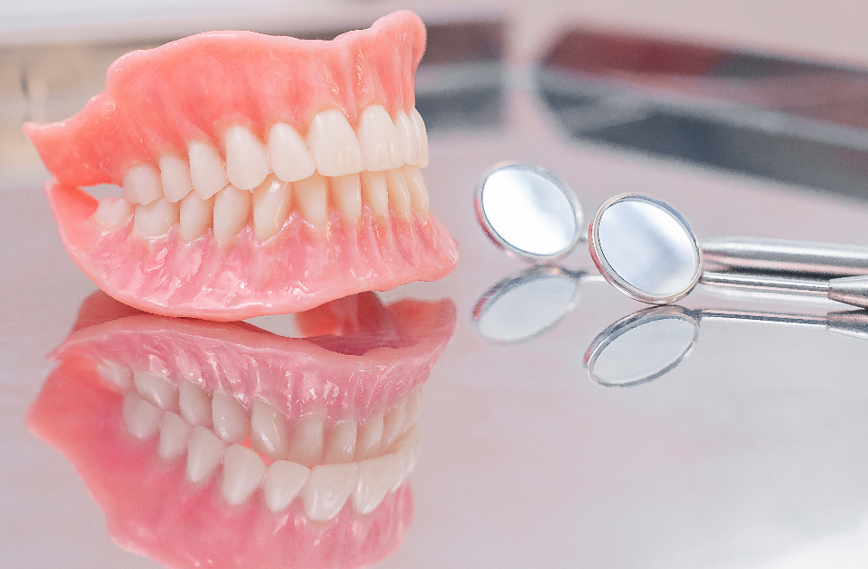 Dentures on desk next to dental mirror