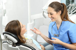 dentist talking to a patient sitting in chair about dental bonding