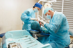 two dental professional in gown are preparing for periodontal surgery